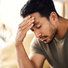 a man rubbing his forehead due to fatigue