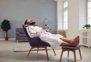 Man wearing a sleep mask and reclining in a comfy chair