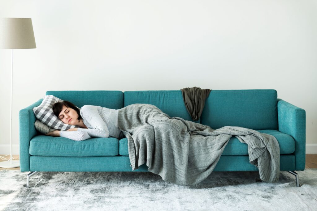 Woman napping on teal couch