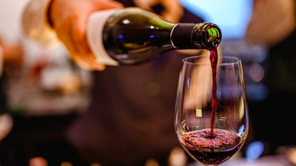 Bartender pouring a glass of red wine